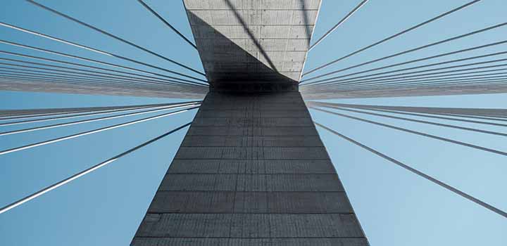 Looking skyward from a modern concrete and steel bridge