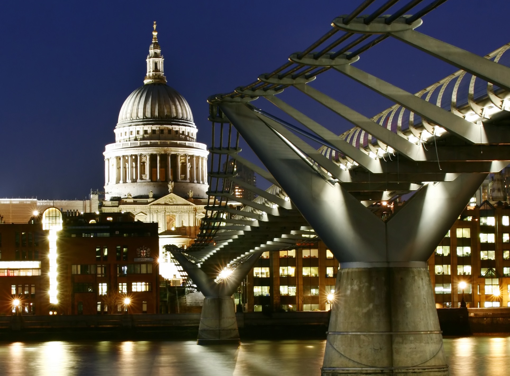 Image of the Millennium Bridge in London, UK and St Pauls Cathedral at night.