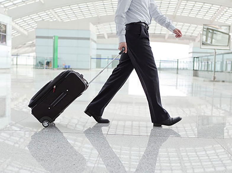 Person walking with suitcase in empty airport