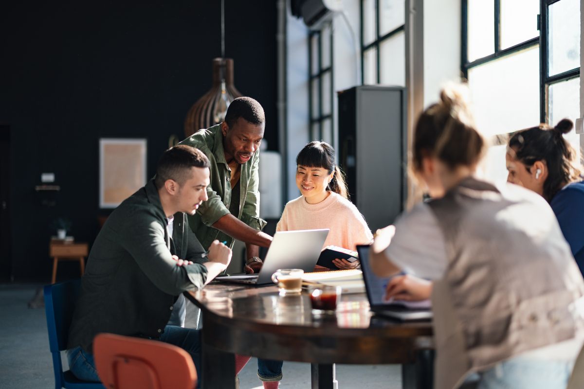 Students working at desk together drinking coffee