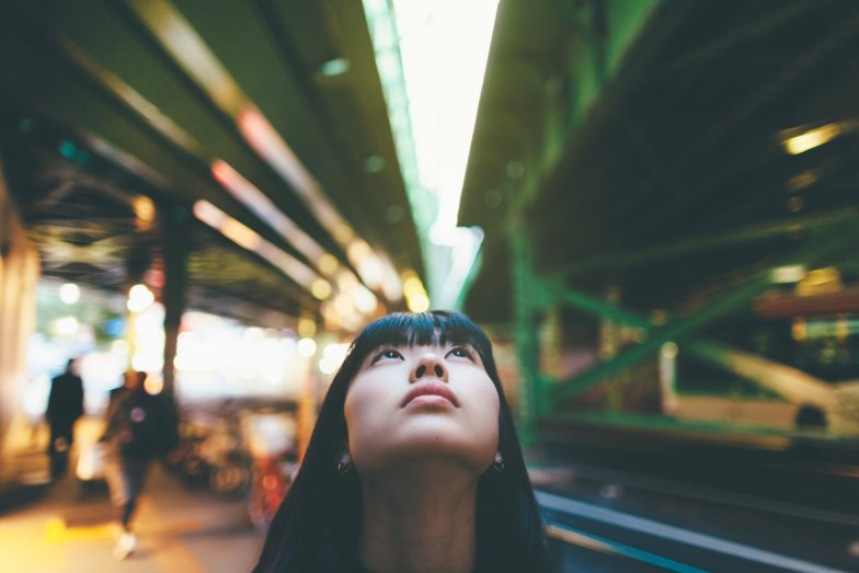 young person looking up between two urban bridges