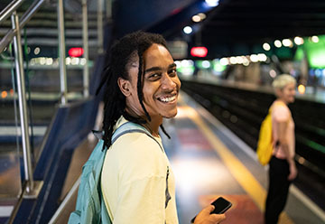 smiling person waiting for train