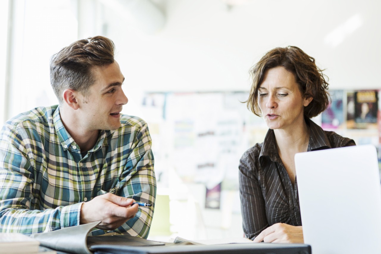 Professor and student talking in classroom