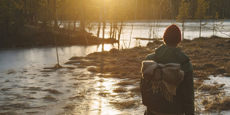 Finland, Esbo, Kvarntrask, Young man standing on marshy lakeshore