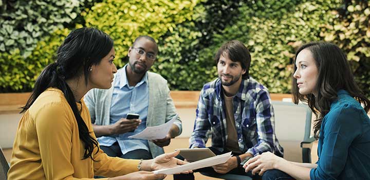 A group of four colleagues in an outdoor meeting