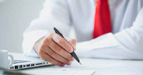 Person wearing a red necktie studying a document