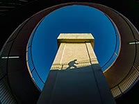 View of a modern structure from below, looking up at clear blue sky