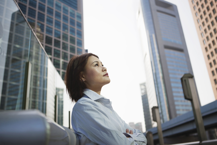 Woman outdoors surrounded by modern glass high rise buildings