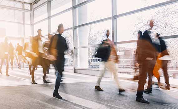 Image on the cover of the report of office workers walking, where each person is slightly blurred