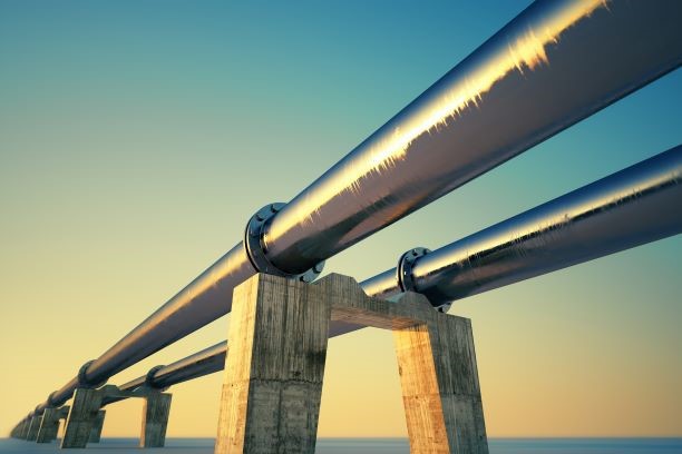 Image of two pipelines resting on concrete supports across a sea or ocean 