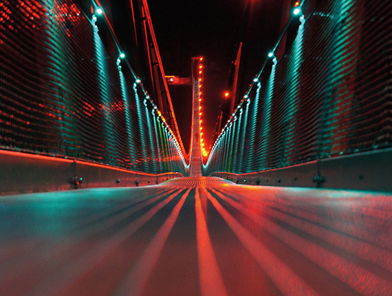 Image of a bridge from the inside at night lit up