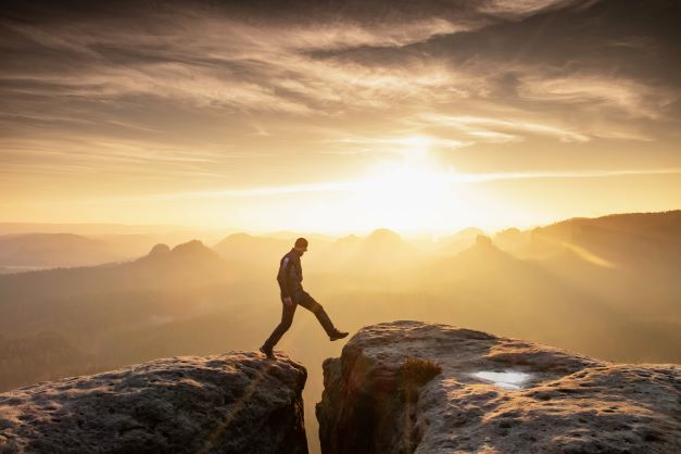 report cover image of a person travessing a gap between cliffs