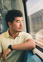 Image of a man looking out a bus window. 