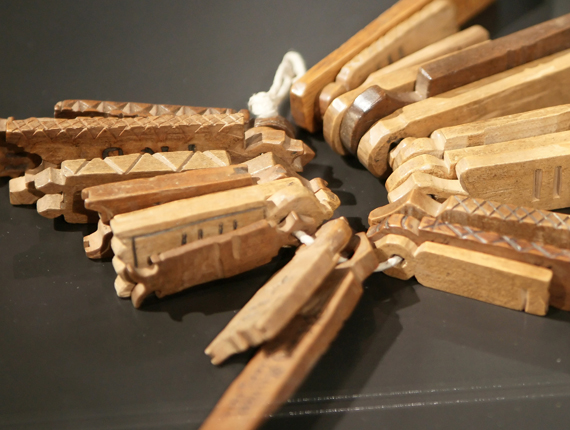 Numerous wooden tools of different shapes tied to a piece of string.