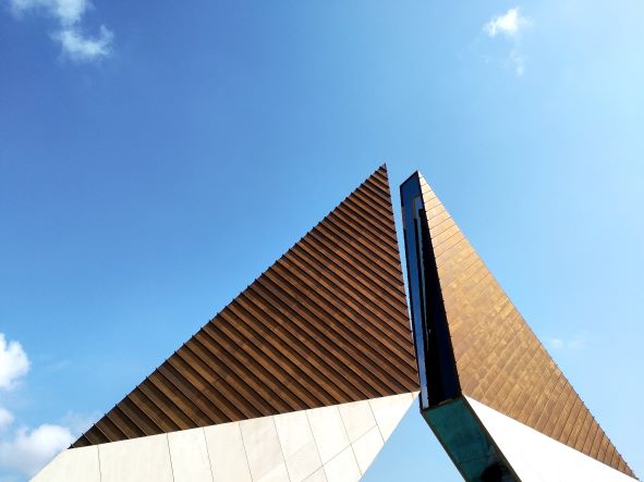 image of roof of a structure resembling two towers with blue skies as backdrop