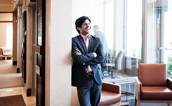 Businessman standing in an office and smiling with crossed arms