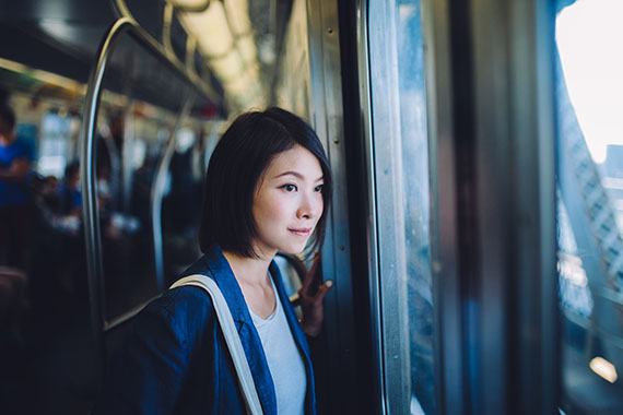 image of a woman looking out the window of a subway train that is on the cover of the report. 