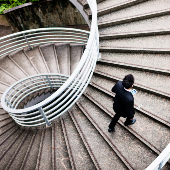 Man walking up a spiral staircase