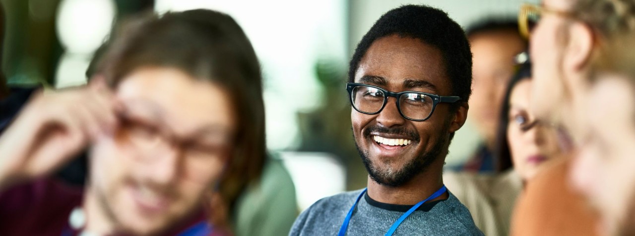 smiling person wearing lanyard in classroom