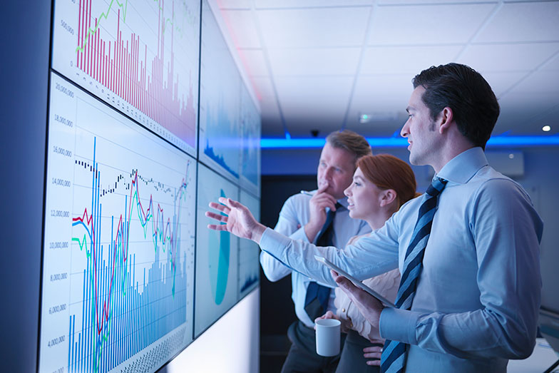 people looking a data on a large screen