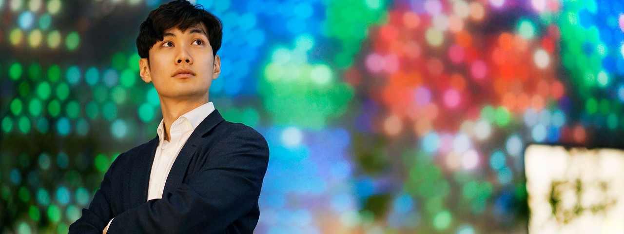 Person looking right in front of vibrant, pixelated background