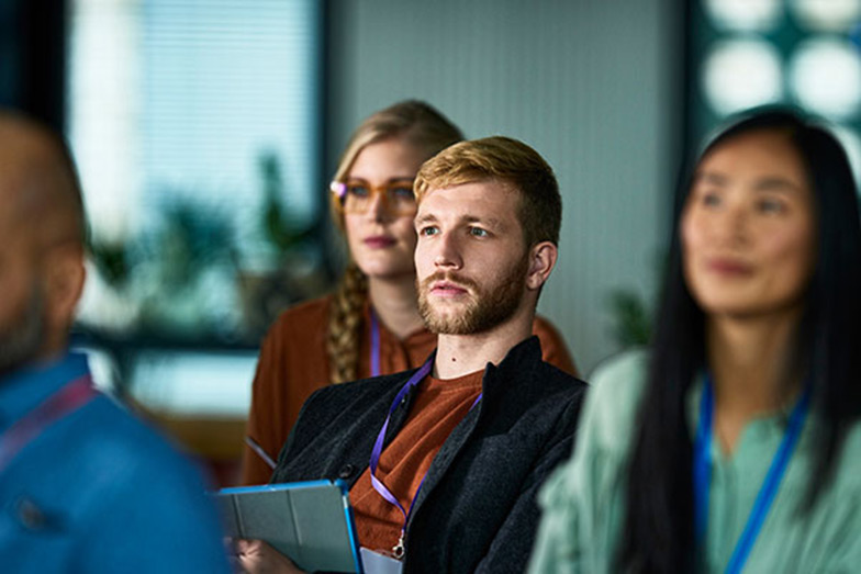 audience at an event with focus on one person looking at the speaker