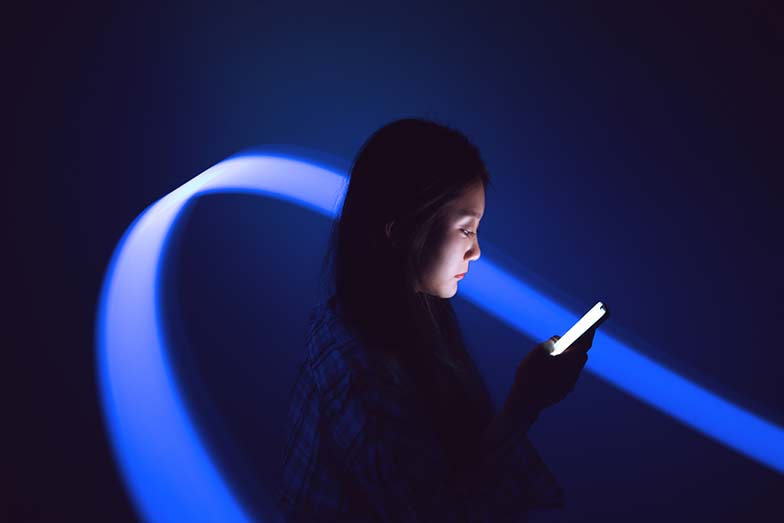 woman holding phone with blue light swoop