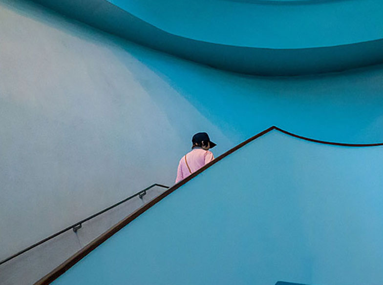 Person climbing blue stairs