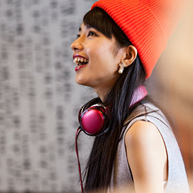Person smiling skywards while wearing headphones