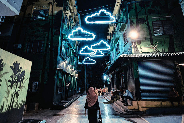 night time street scene with blue cloud neon lights overhead