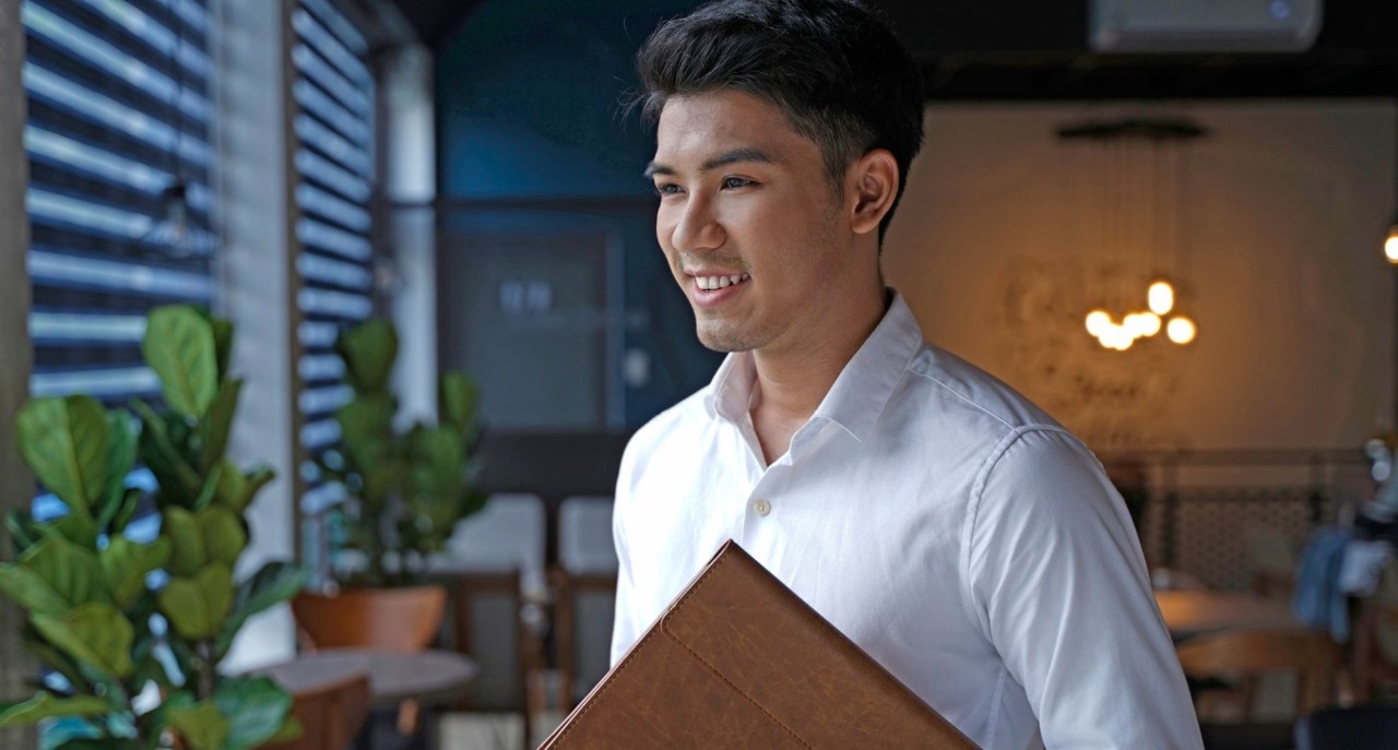 Young person carrying laptop case looking out of window