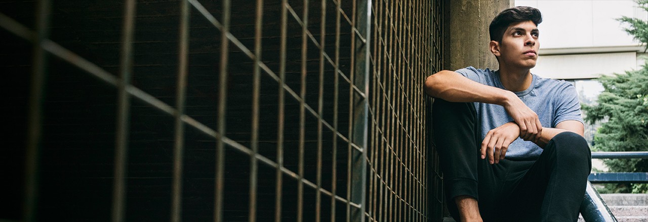 person sitting on steps next to railings