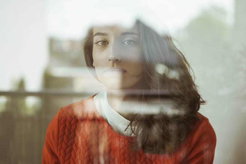 young woman with reflections on face and sad expression