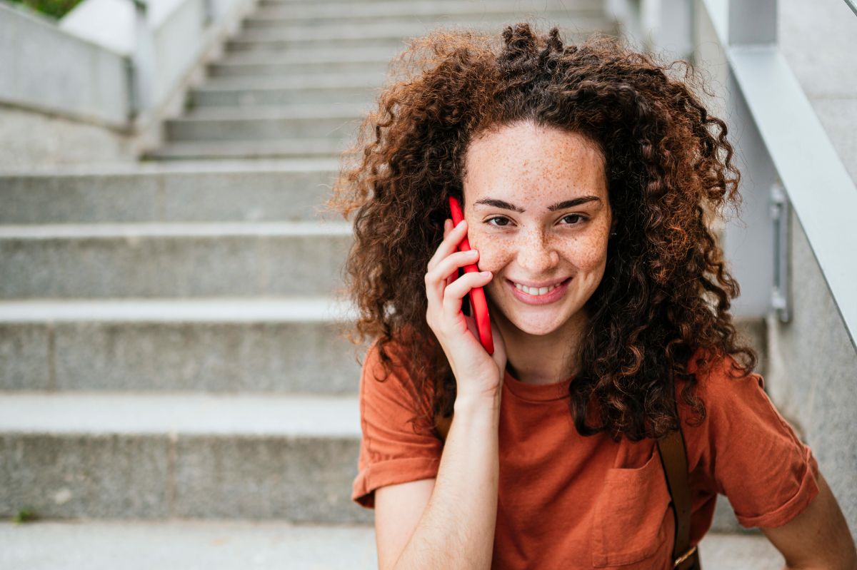 young person sitting on steps on mobile phone