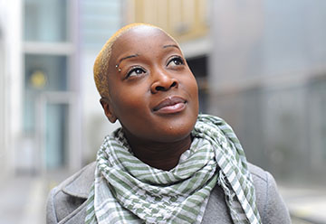 Person wearing grey scarf looking skywards 