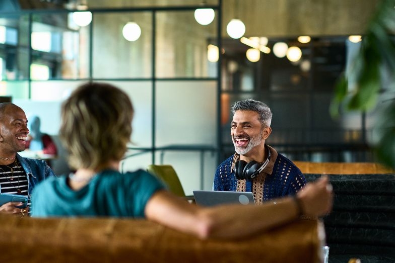 person laughing with two colleagues in modern office