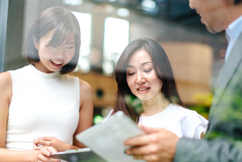 group of office workers looking at clipboards and chatting