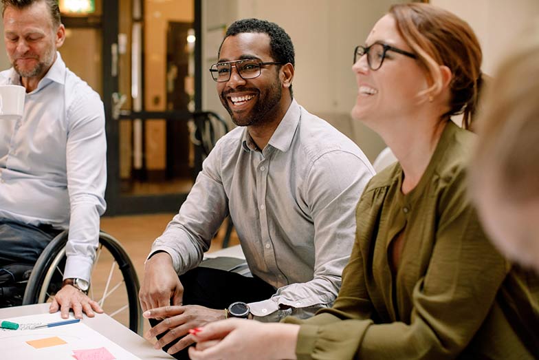 man sitting in group with others smiling