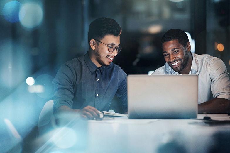 Two men laughing over computer