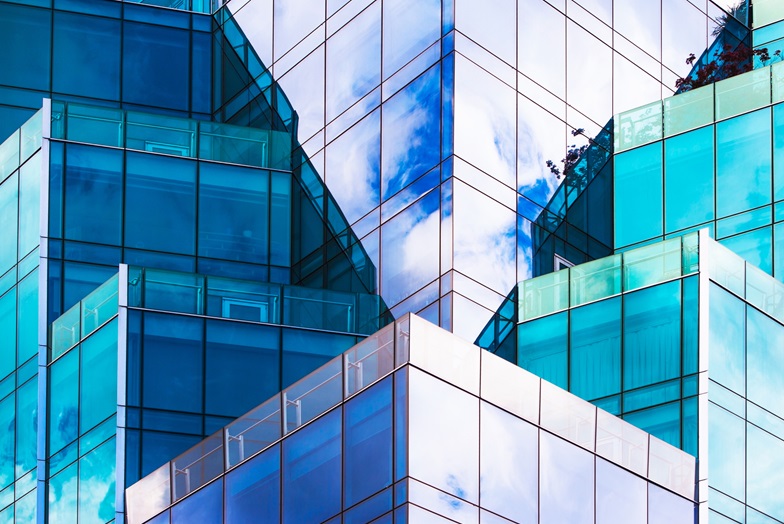 The sky reflected onto a tiered glass building