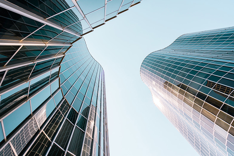A skywards view of curving glass buildings