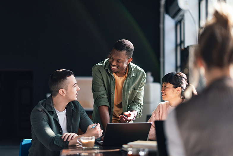 People talking around a laptop