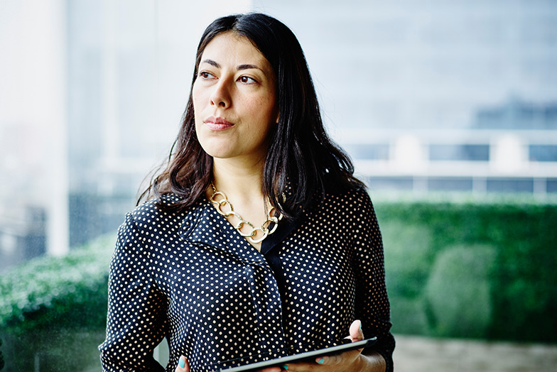 Person with contemplative expression holding a tablet device