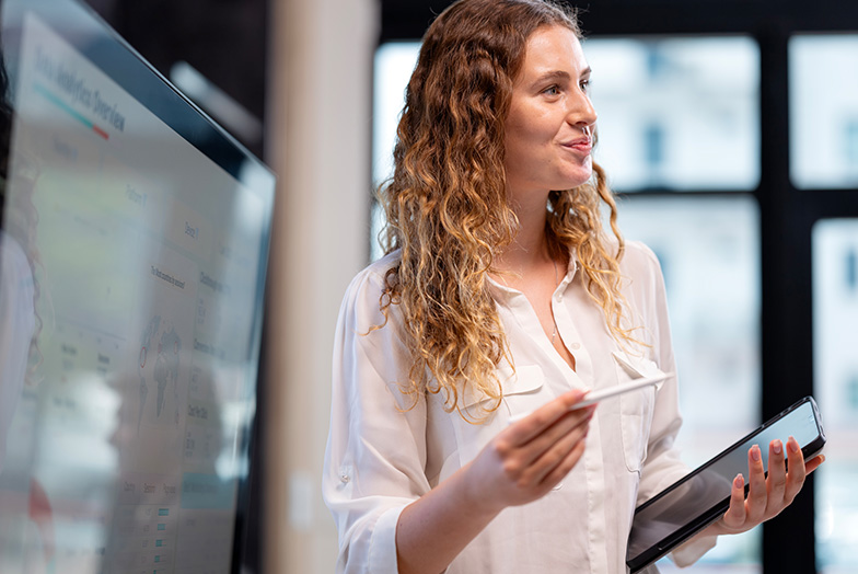 Person in front of a board with tablet in hands
