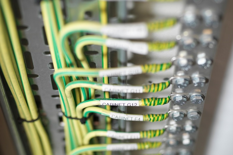 Close up of yellow and green wires in a cabinet
