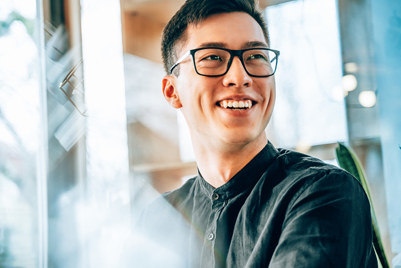 A smiling person wearing glasses