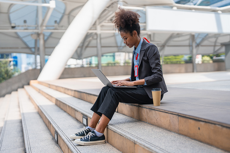 Person sitting on steps using a laptop