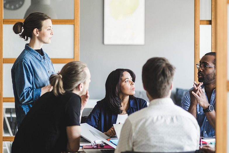 Five people around a desk.