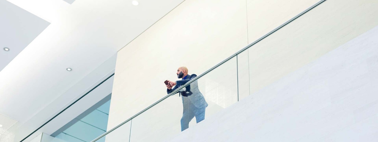 man leaning over balcony in office