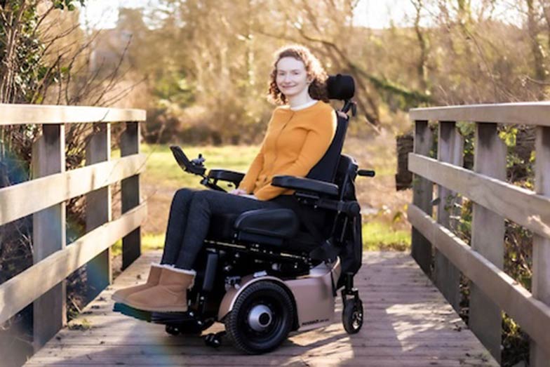 woman sitting in a wheelchair on a bridge